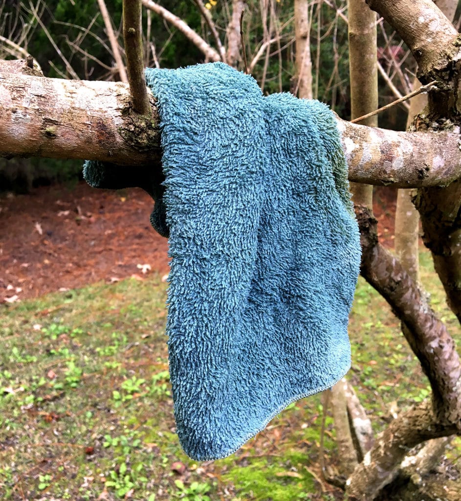A small towel hangs on a tree to dry.