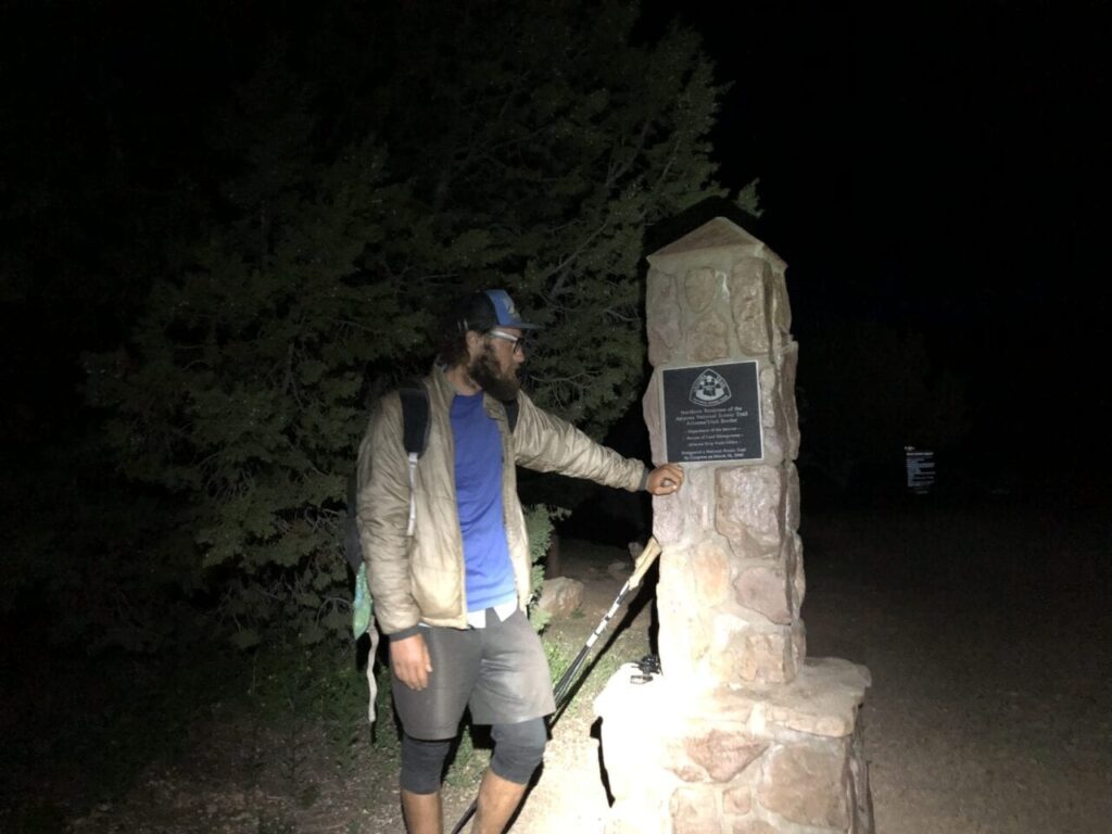 A hiker posing at the terminus of the Arizona Trail