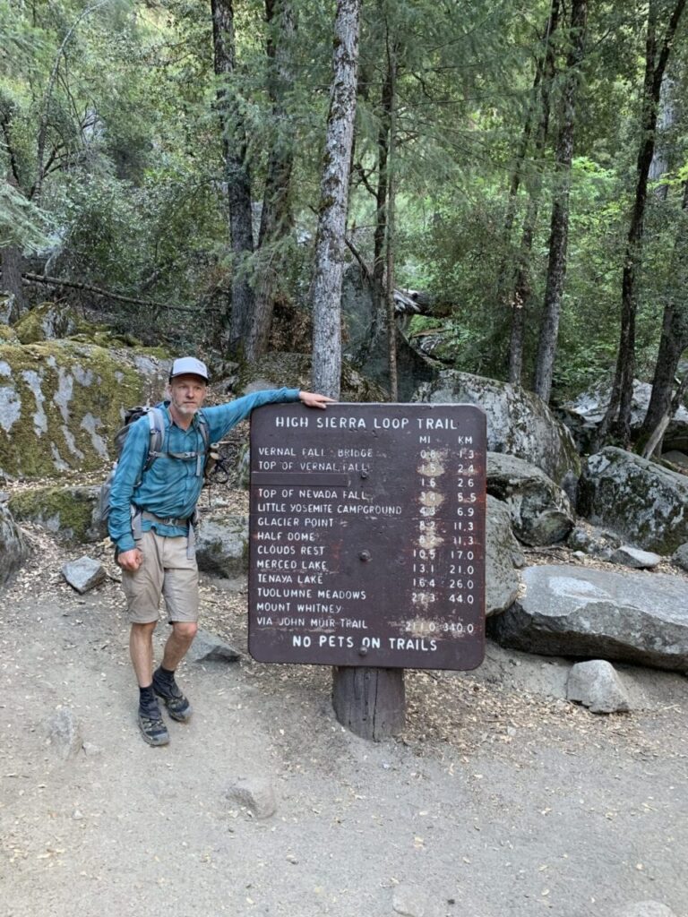 John Muir Trail thru hiker standing at the northern terminus of the JMT.