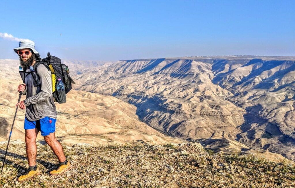 2019 thru-hiker hiking with spectacular canyons below.