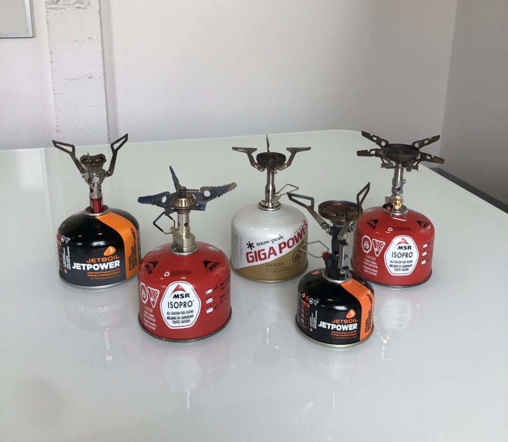 Five different backpacking stoves attached to five different fuel canisters