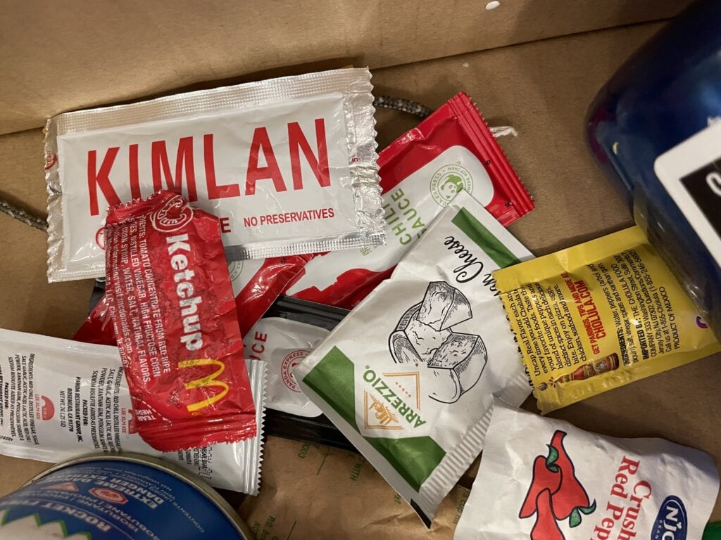 a pile of sauces and peppers in small sealable packages