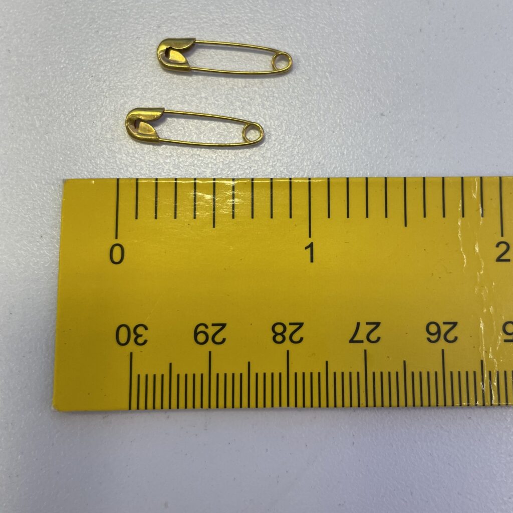 Safety pins being measured in length