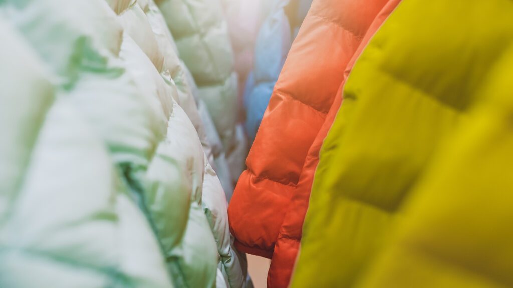 Colorful down and synthetic jackets hanging, down vs. sysnthetic