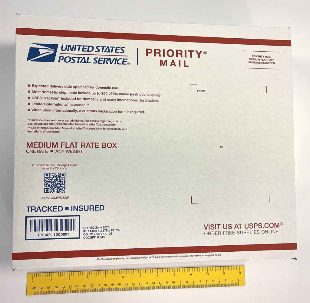 A priority mailing package next to a ruler