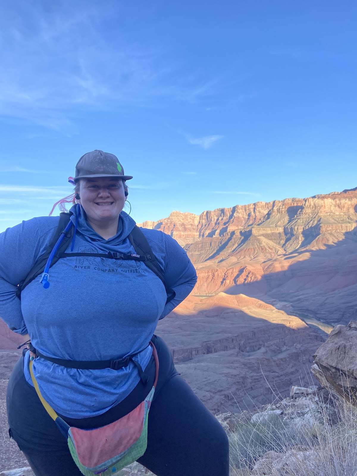 a woman hiking and posing in front of the Grand Canyon