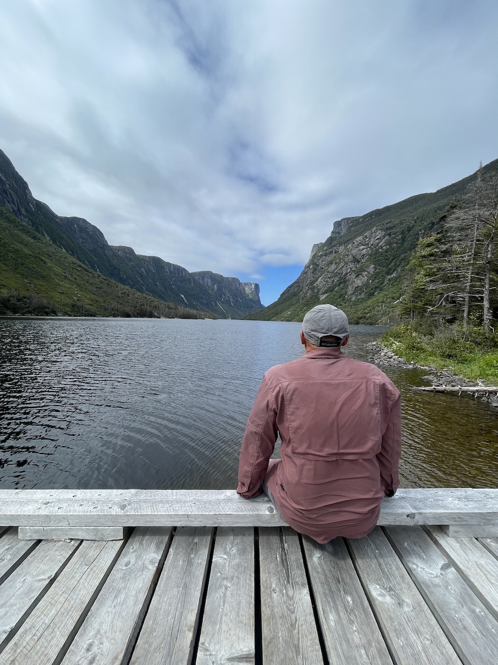 A hiker sitting on a bridge looking out on a lake on the ECT