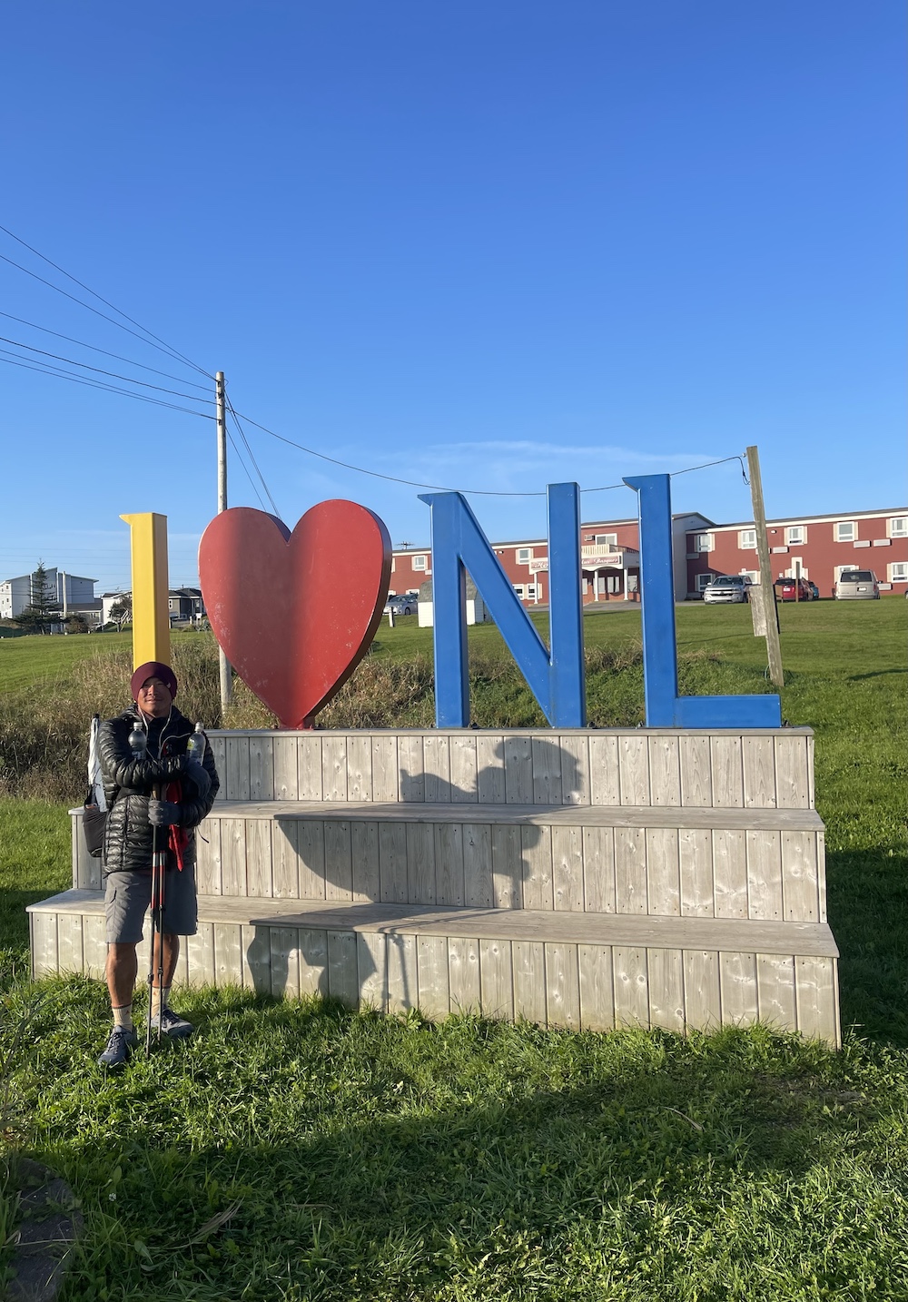 a hiker standing by a sign that says I love NL