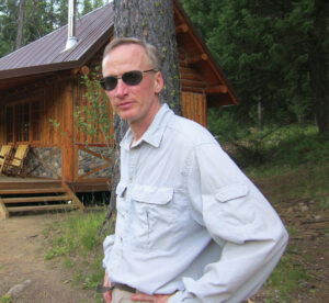 a man in front of a cabin