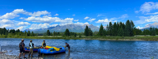 whitewater rafters on the bank of a river