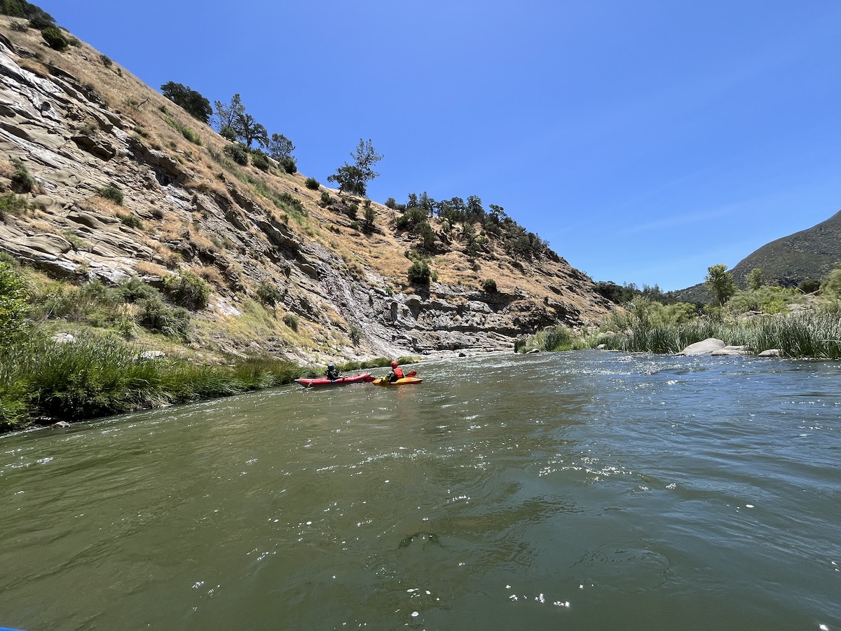 two kayakers along the edge of cache creek