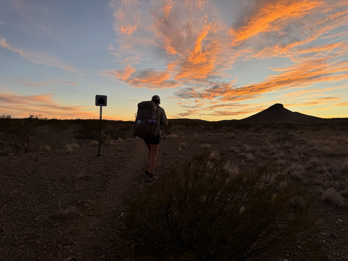 a hiker outline with the sunset