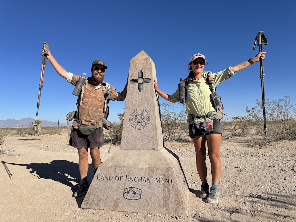 two hikers posing next to the souther terminus of the continental divide trail