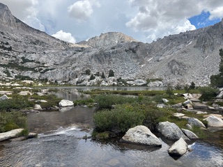 mountain with water and rocks at the base