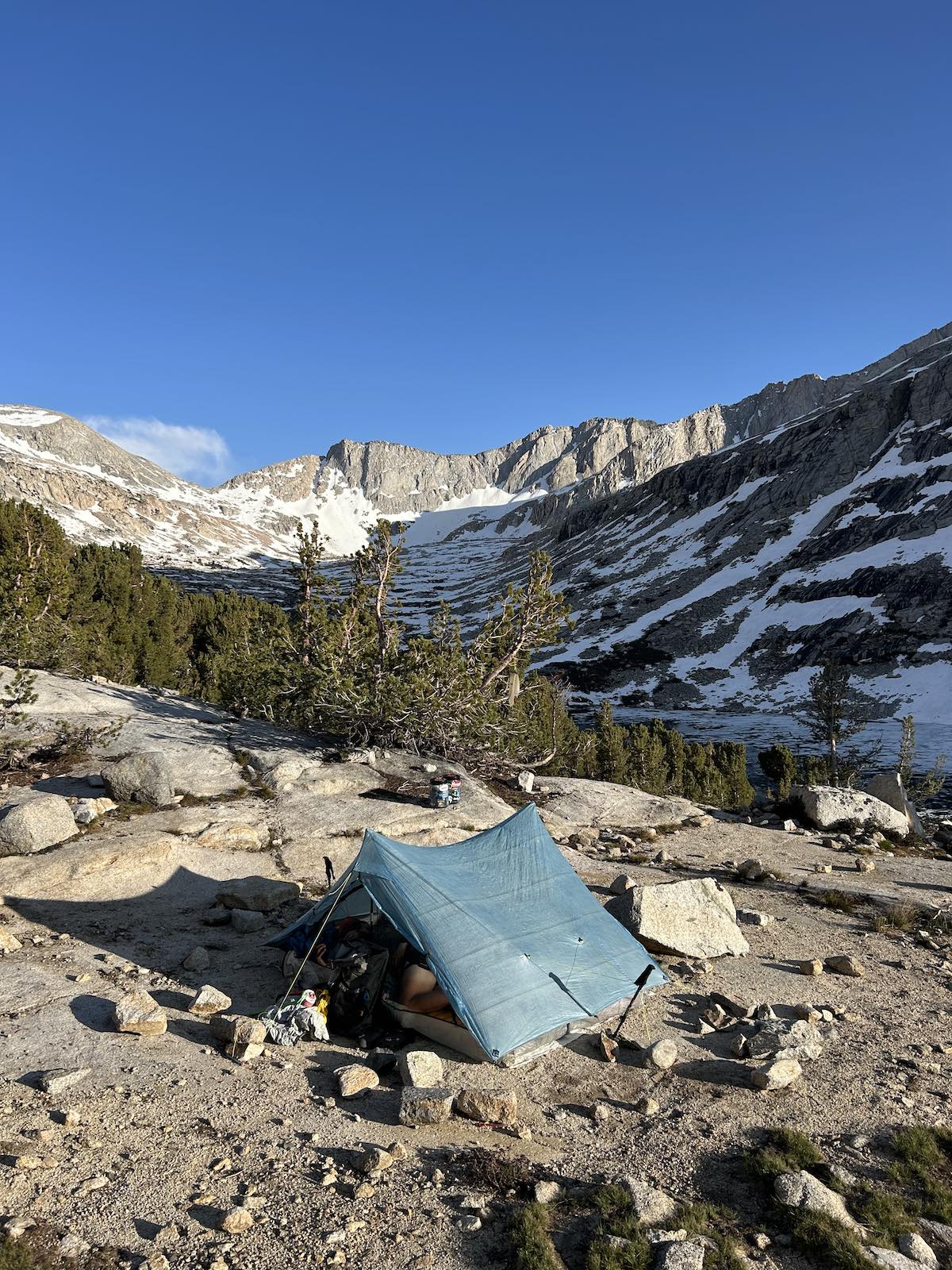 a tent at the base of a snowy mountain