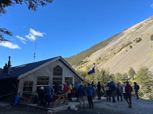 hikers standing on a patio outside a building with a mountain in the background