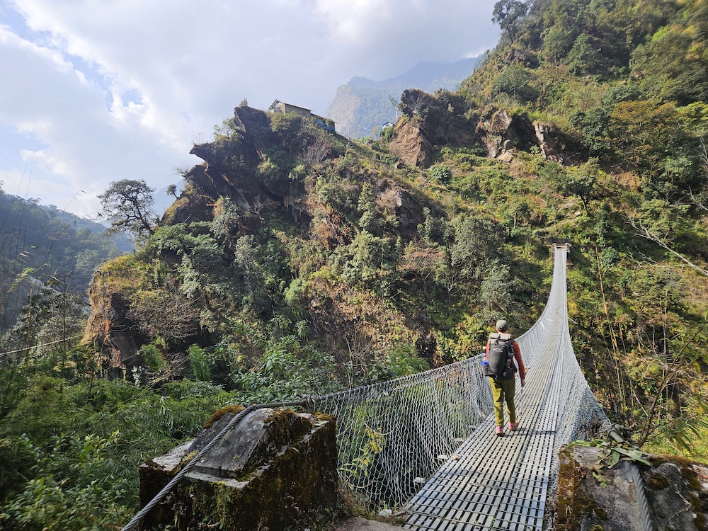 great-himalaya-trail-bridge a hiker on a suspension bridge on the Great Himalaya Trail