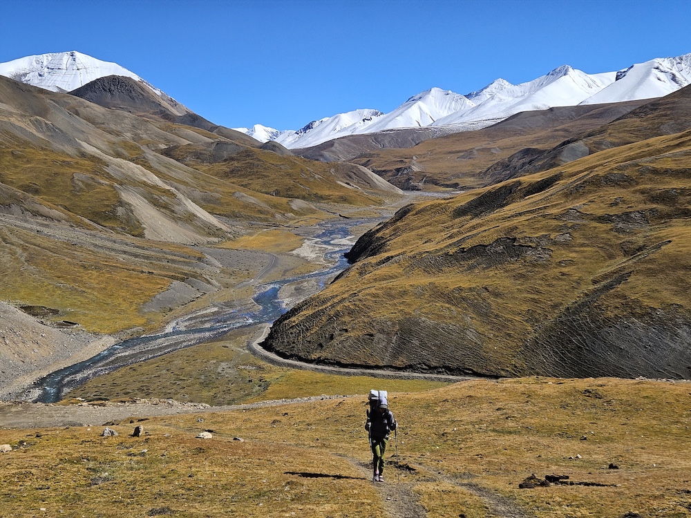 great-himalaya-trail-hiker a hiker on a trail with mountains and hills in the background