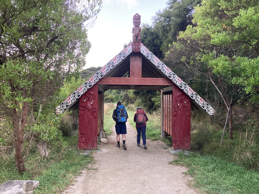 abel-tasman-coast-track-2 two hikers walking through a gate